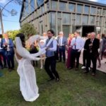 Novia bailando en el césped rodeada de invitados durante un cóctel de boda