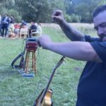 Músico prepara equipo y anima a invitados en un coctel de boda al aire libre