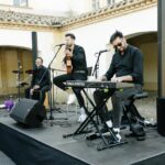 Trío musical toca en un patio español, ideal para cóctel de boda